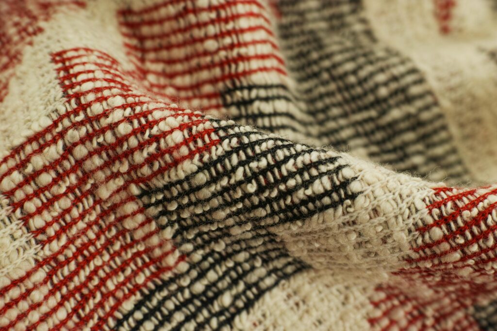 Detailed view of a red and black checked handwoven textile showcasing texture and craftsmanship.