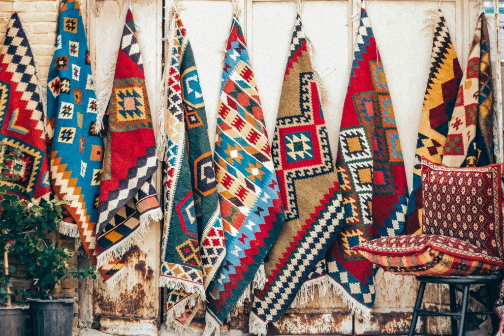 Vibrant Persian rugs hung for display in Shiraz, showcasing traditional Iranian craftsmanship.