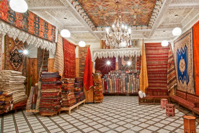 Colorful carpets and intricate decor in a Moroccan store showcasing traditional craftsmanship.
